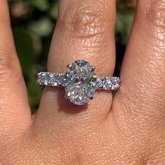 a woman's hand with a diamond ring on top of her finger and an engagement band