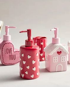 soap dispensers and toothbrushes are arranged on a white surface with hearts