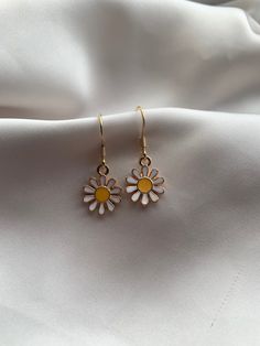 A summer statement that never goes out of style. Daisies are a girls best friend and what better to way them as earrings. Go from day to night with this classic Daisy charm. Whether you choose botanical aesthetic or going for a floral vibe then these earrings are the one for you!  This simple Daisy design features a gold plated charm with groovy style of petals blooming with a flat yellow centre.  Grab these for yourself or give away to a Daisy lover!  Each earring is handmade by myself.  All ea Gold Flower Charm Earrings For Summer, Nickel-free Flower Drop Earrings For Summer, Gold Flower Earrings For Pierced Ears, Summer Season, Gold Drop Flower Earrings For Summer, Single Summer Flower Earring, Nickel Free Flower Earrings For Summer, Nickel-free Flower Earrings For Summer, Gold Flower Earrings For Summer, Gold Flower-shaped Jewelry For Summer