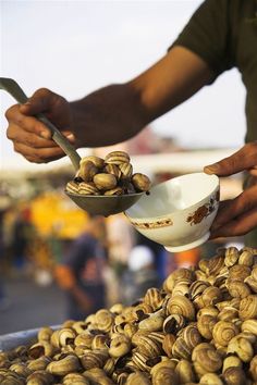 a man is scooping snails out of a bowl