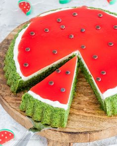 a watermelon cake on a wooden platter with one slice cut out and ready to be eaten