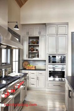 a kitchen with white cabinets and stainless steel appliances