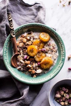 a bowl filled with oatmeal topped with bananas and nuts next to a spoon