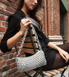 a woman sitting on a bench holding a purse