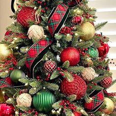 a christmas tree decorated with red, green and gold ornaments