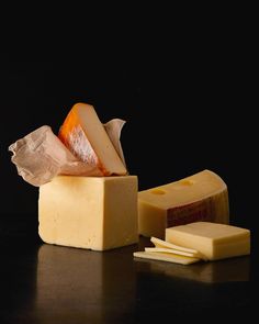 several different types of cheese on a black surface