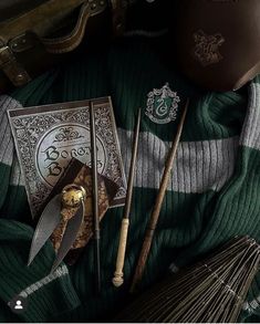 the contents of a harry potter costume are laid out on top of a green blanket