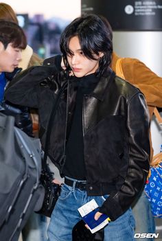 a man with black hair wearing a leather jacket