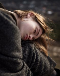 a woman with her eyes closed laying down