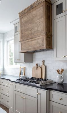 a kitchen with white cabinets and black counter tops