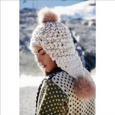 a woman wearing a knitted hat with pom - poms on it's head