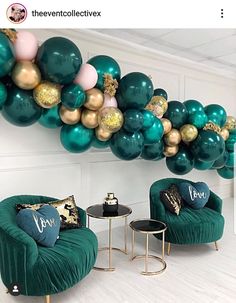 a room filled with green velvet chairs and gold foil balloons hanging from the ceiling above them