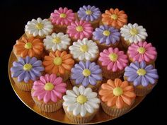 cupcakes decorated with colorful flowers on a gold plate