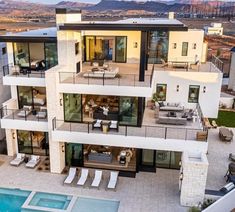 an aerial view of a modern home with pool and outdoor furniture in the foreground