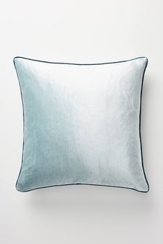 a light blue pillow on a white wall