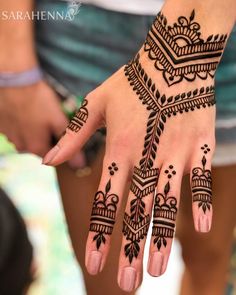 a woman's hand with henna tattoos on it