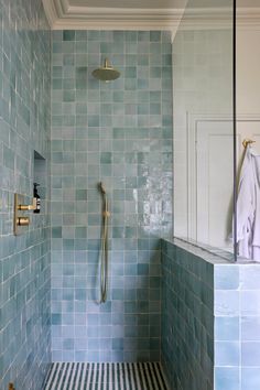 a bathroom with blue tiles and a shower head