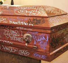 a chest covered in graffiti sitting on top of a table