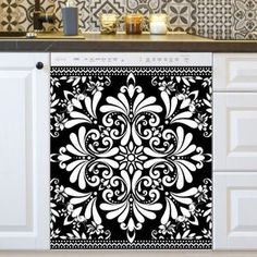 an ornate black and white design on the side of a kitchen cabinet