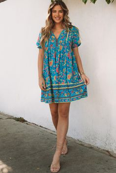 Blue Floral Print Empire Waist Flowy Dress Blue Flowy Boho Dress With Short Sleeves, Blue Short Sleeve Boho Sundress, Casual Flowy Turquoise Dress, Casual Turquoise Dress For Day Out, Blue Bohemian Mini Dress Knee-length, Blue Bohemian Knee-length Mini Dress, Casual Turquoise Floral Print Dress, Blue Floral Print Boho Dress With Short Sleeves, Blue Floral Print Boho Sundress