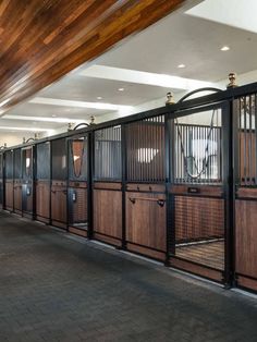 the inside of a horse stable with wooden stalls