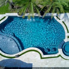 an aerial view of a swimming pool surrounded by palm trees