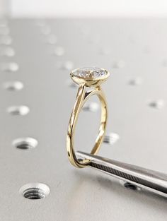 a diamond ring sitting on top of a piece of metal