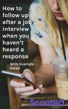 a woman sitting at a table with a drink and cell phone in her hand, texting how to follow up after a job interview when you haven't heard a response