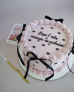 a birthday cake with writing on it sitting next to a pair of scissors and an envelope