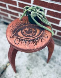 a wooden stool with an eye painted on it