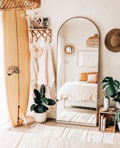 a bedroom with a surfboard in the corner and a mirror on the wall next to it