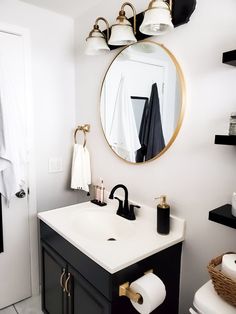 a black and white bathroom with gold accents