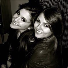 two young women are posing for the camera in this black and white photo, one has her arm around the other's shoulder