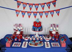 a spiderman birthday party with cake and cupcakes on a blue table cloth