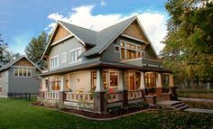 a large gray house with lots of windows on the front and side of it's roof