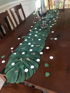 a long table with green leaves and white dots on it