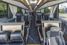 the inside of an empty bus with black seats and white drapes on the windows