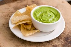 a white plate topped with guacamole and tortilla chips