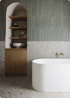 a white bath tub sitting next to a wooden shelf