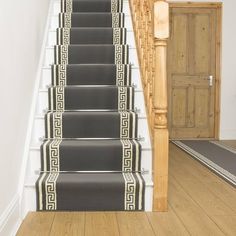 the stairs are painted black and white with greek designs on them, along with carpeted flooring