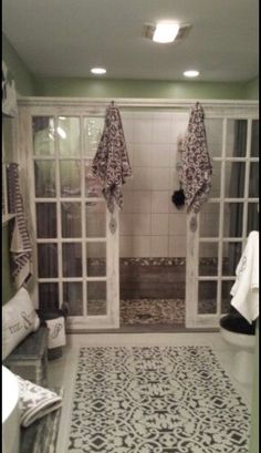 a bathroom with green walls and white tile flooring, two large windows on each side of the bathtub