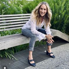 a woman sitting on top of a wooden bench