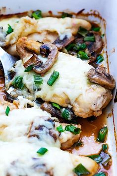 a pan filled with chicken covered in mushrooms and cheese