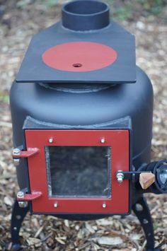 an old fashioned stove sitting on top of some wood chips in the grass and leaves