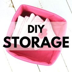 a pink storage bin filled with cloths on top of a white wooden floor and the words diy storage above it