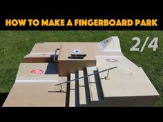 a skateboard park with steps and ramps in the grass, next to a sign that says how to make a fingerboard park