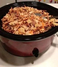 a crock pot filled with cheetos and crackers