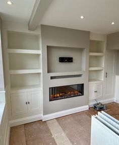 an empty room with built in shelves and a fireplace