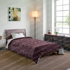 a bed room with a neatly made bed and a night stand next to a window