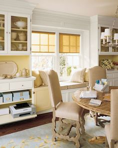 a dining room table surrounded by chairs in front of a window with yellow shutters